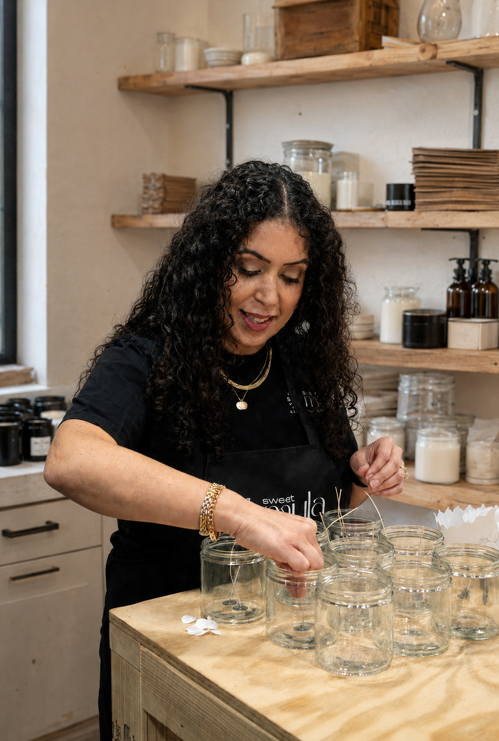 Yadi, founder of Sweet Myla, handcrafting coconut soy candles in her studio.