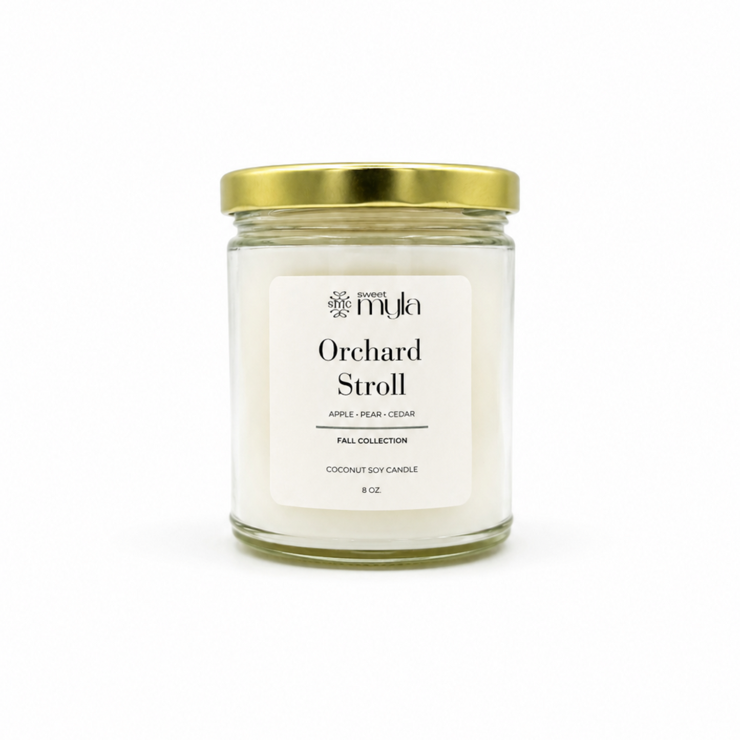A 8oz soy candle in a clear glass jar with a white label and a gold metal lid, labeled 'Orchard Stroll' by the brand Sweet Myla