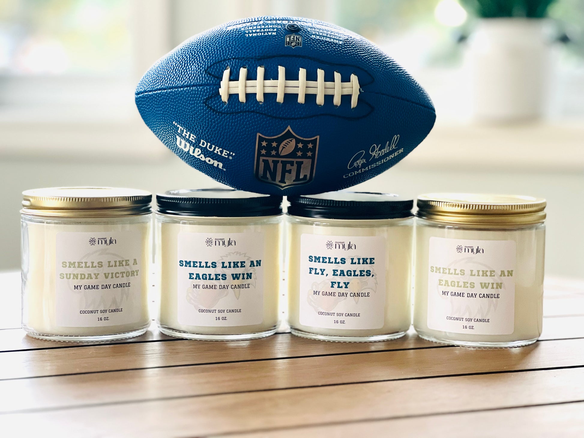 Four candles with white label that start with Smells like…