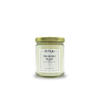 Candle jar with scents of aquatic, grapefruit, magnolia, musk and labeled 'The Secret Place' on a white background