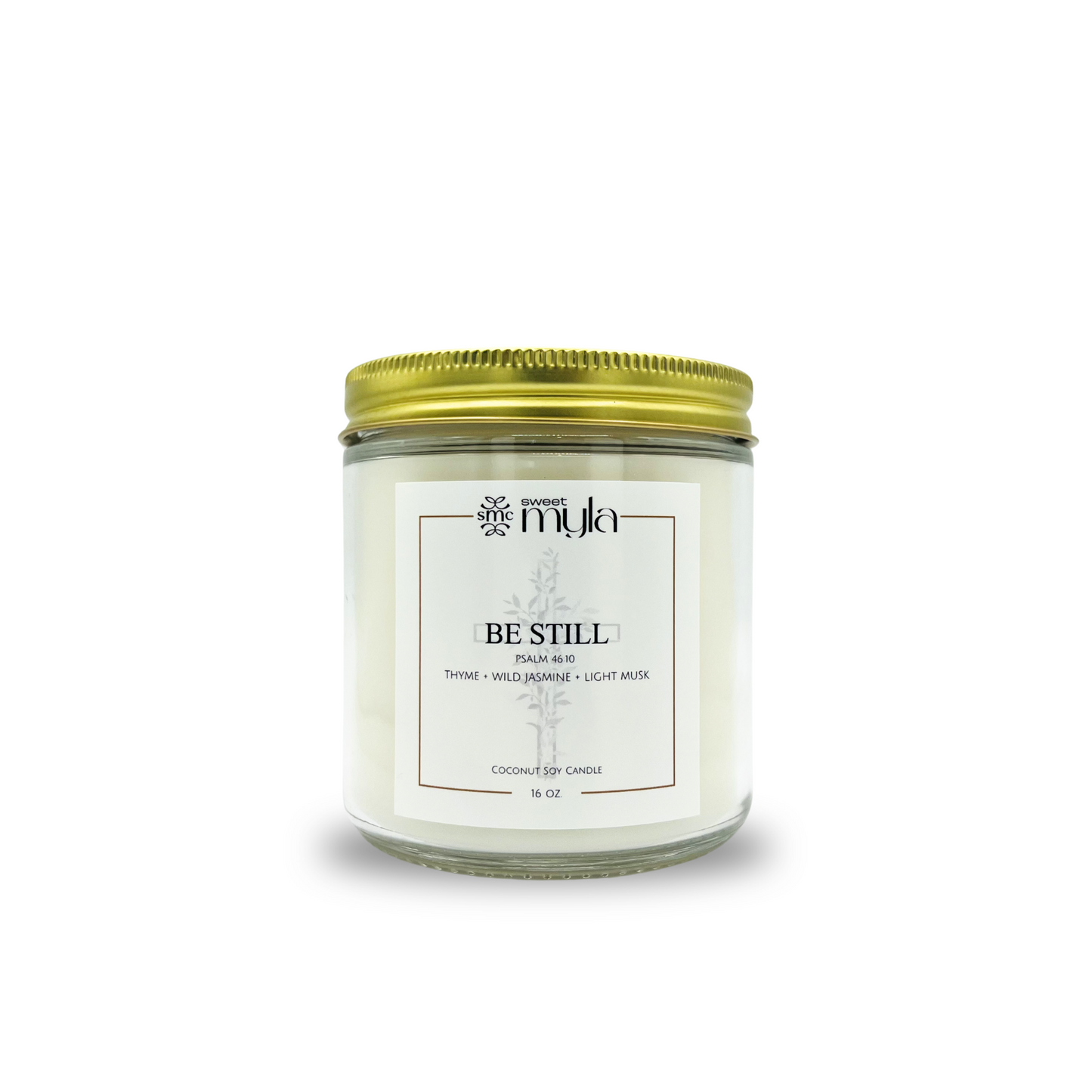 Candle jar with a gold lid labeled 'Be Still' on a white background