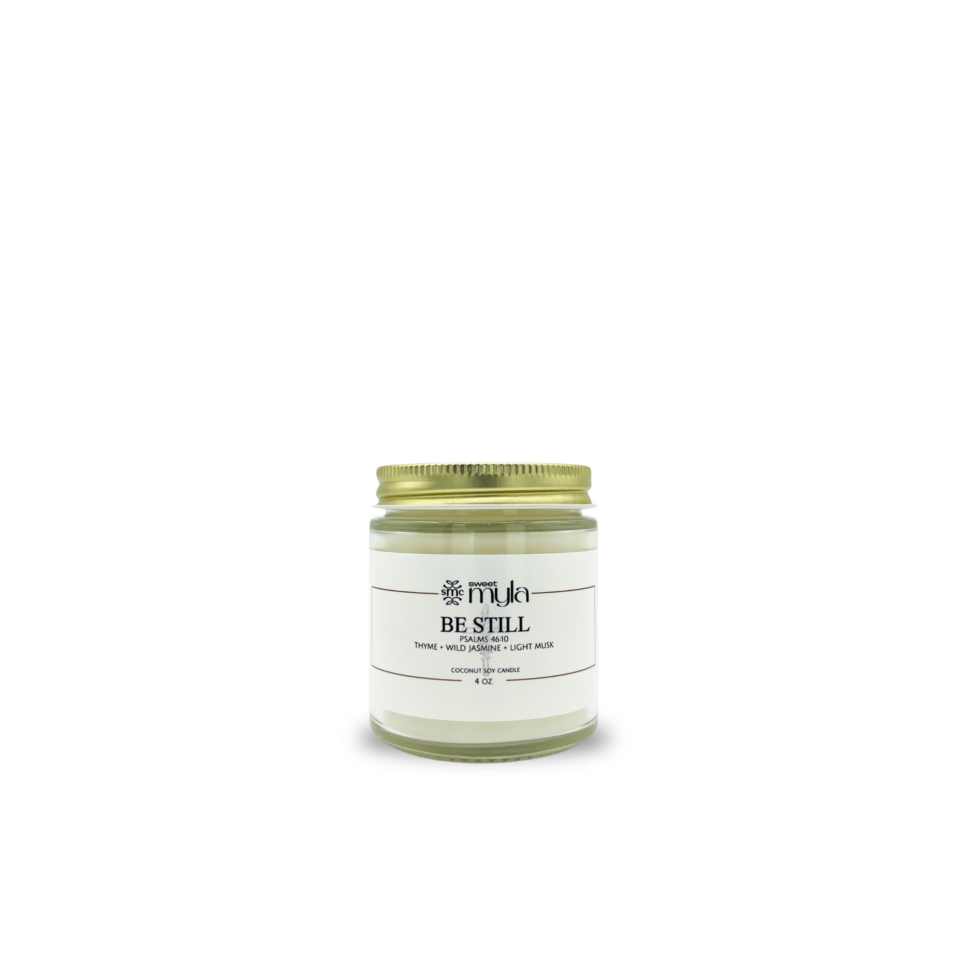 Candle jar with a gold lid labeled 'Be Still' on a white background