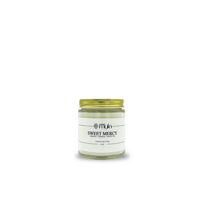 Candle jar labeled 'Sweet Mercy' with a gold lid on a white background