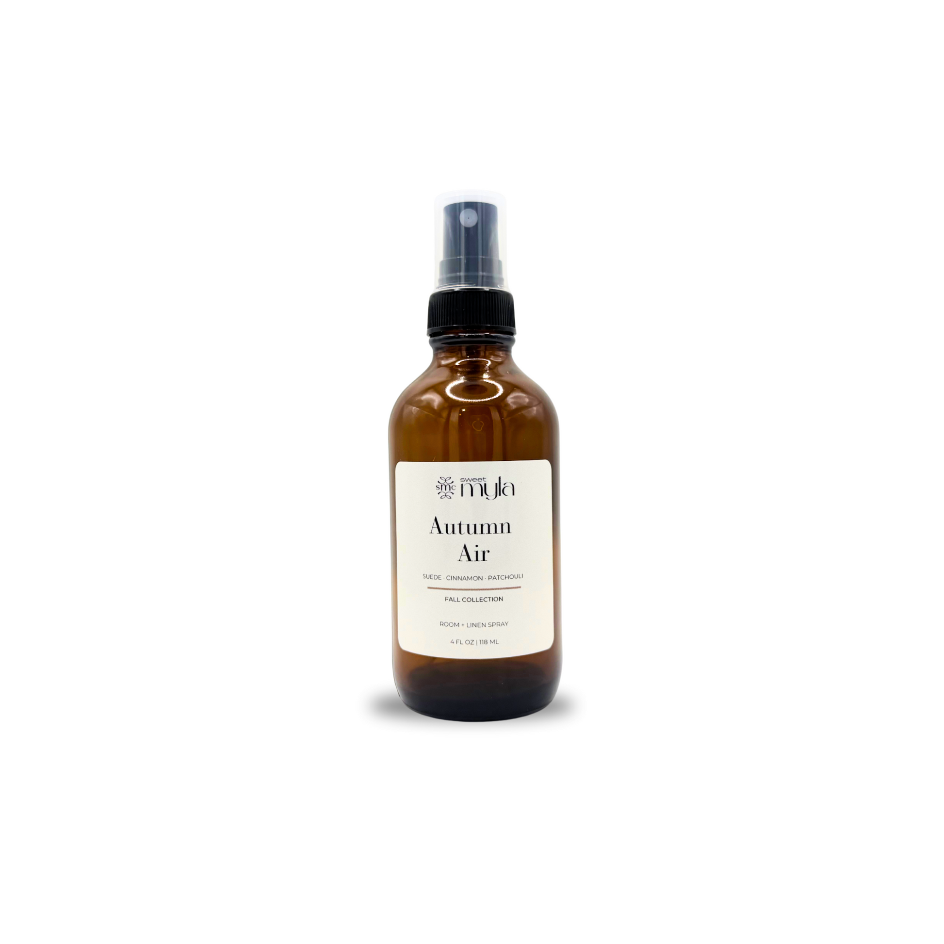 An amber glass spray bottle with a black spray nozzle and a cream-colored label reading 'Autumn Air' on a plain white background by Sweet Myla. 