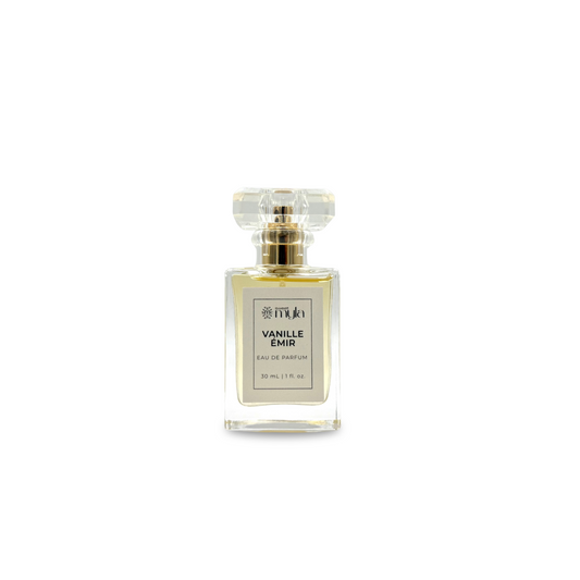 A rectangular clear perfume bottle with a clear faceted cap and a gold collar, featuring a white label that reads 'VANILLE EMIR EAU DE PARFUM'.