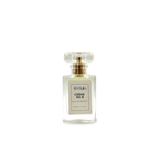 A rectangular clear perfume bottle with a clear faceted cap and a gold collar, featuring a white label that reads 'CREME NO. 8 EAU DE PARFUM'.