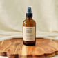 Amber glass spray room and linen bottle labeled  'Timeless Vanilla' 