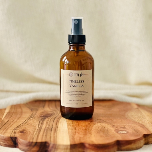 Amber glass spray room and linen bottle labeled  'Timeless Vanilla' 