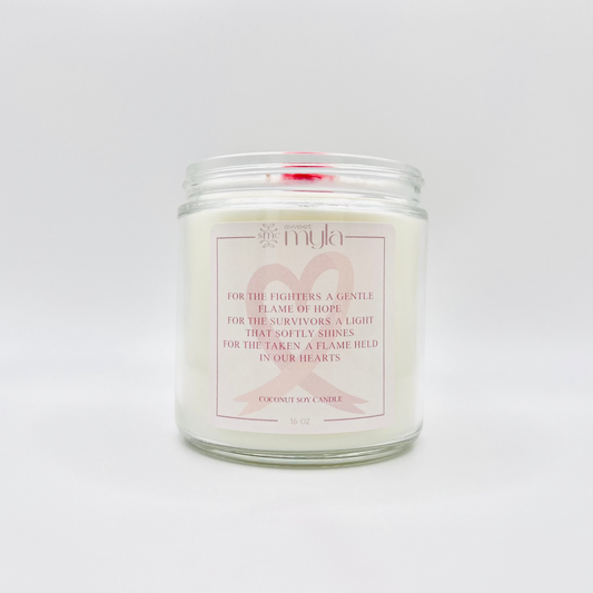 Candle in a glass jar with a label and a cancer awareness ribbon on a white background