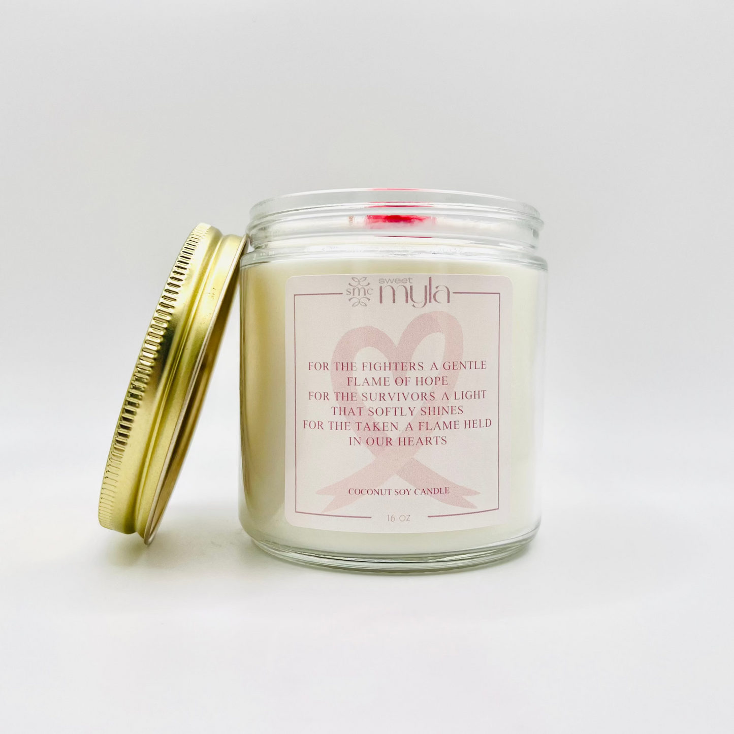 Candle jar with a pink label and a cancer awareness ribbon on a white background