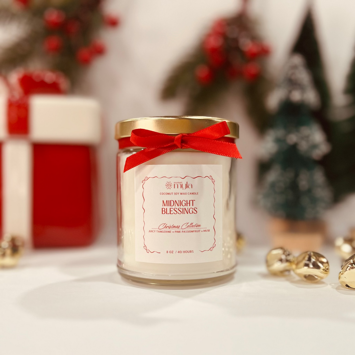 Candle jar labeled 'Midnight Blessings' with a red ribbon, Christmas decorations in the background