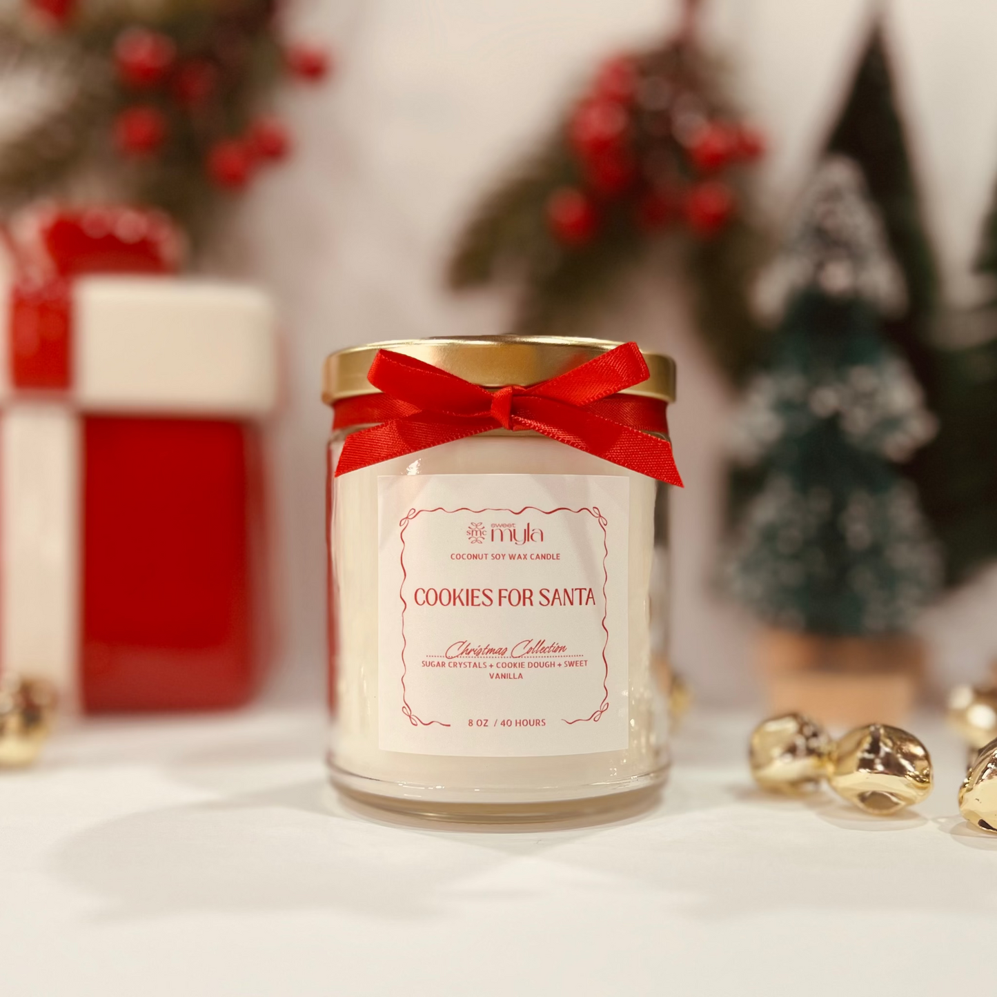 Candle with a red bow in front of Christmas decorations