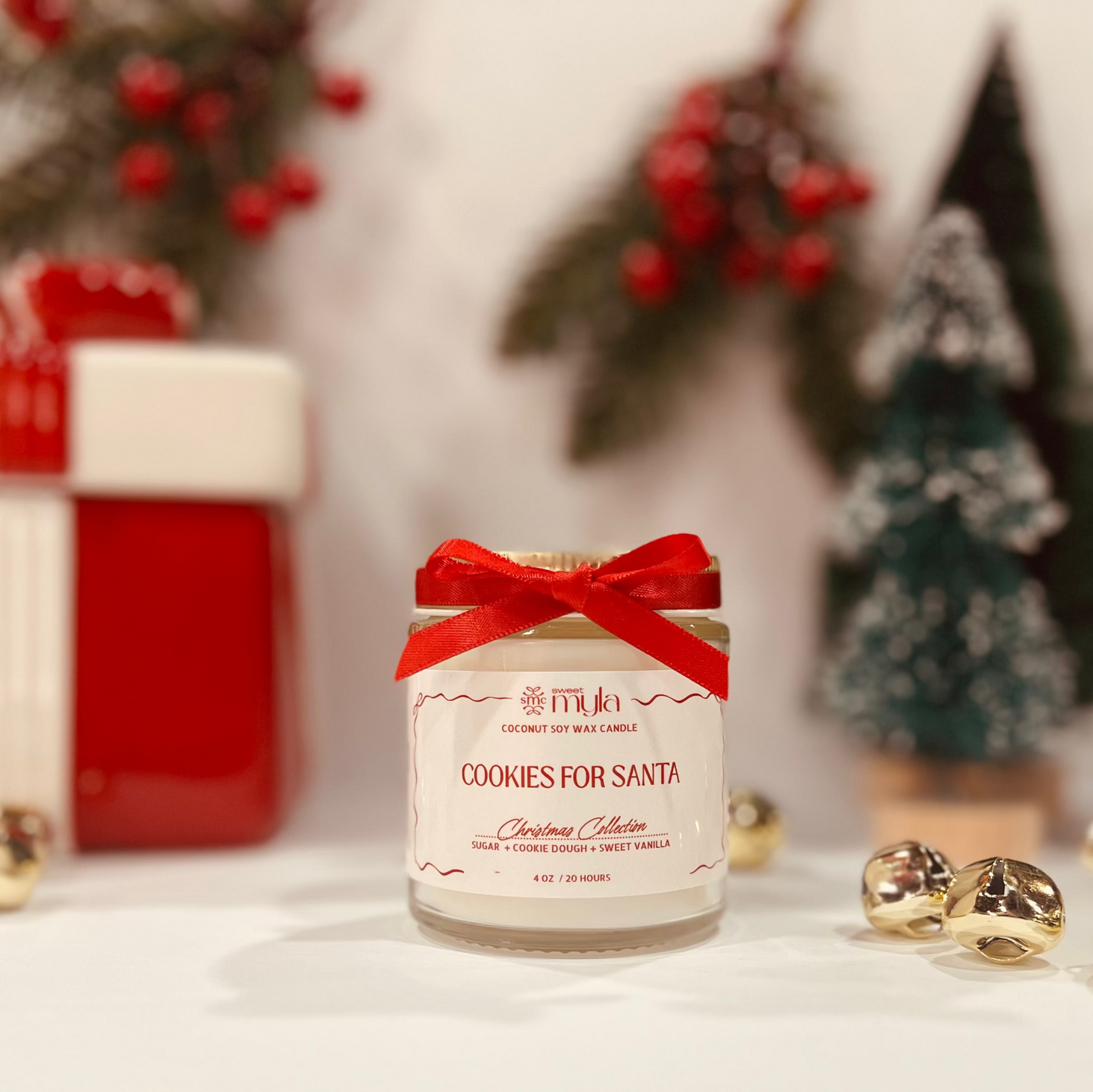Candle labeled 'Cookies for Santa' with a red bow, surrounded by Christmas decorations.