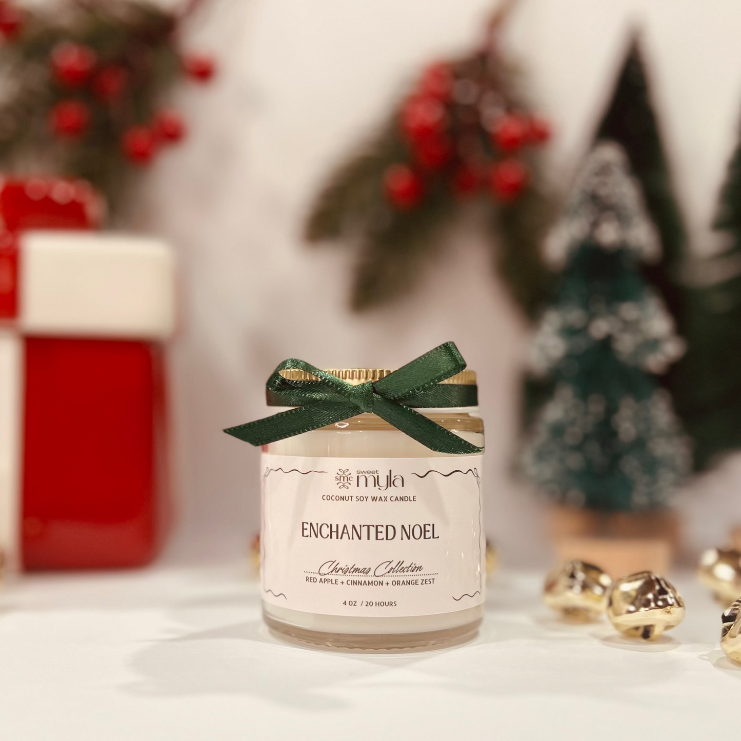 Candle labeled 'Enchanted Noel' with decorative elements in the background