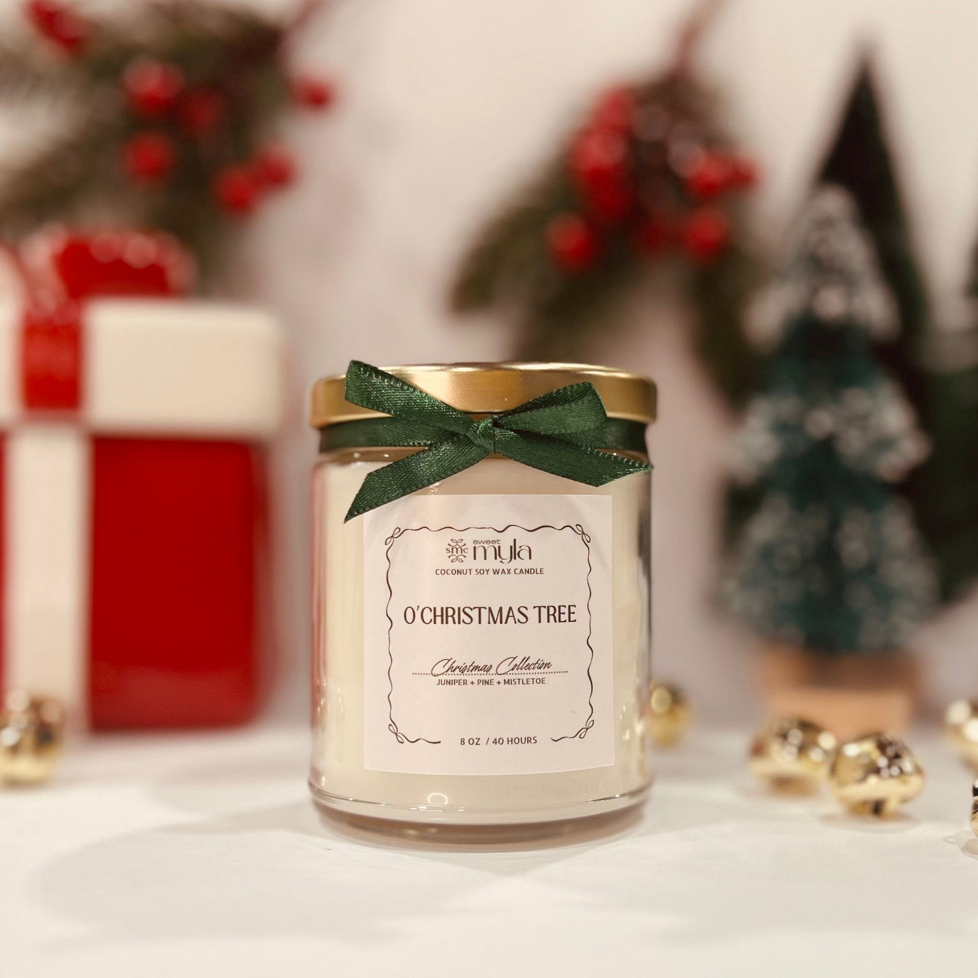 Candle labeled 'O' Christmas Tree' with a green bow, surrounded by festive decorations.