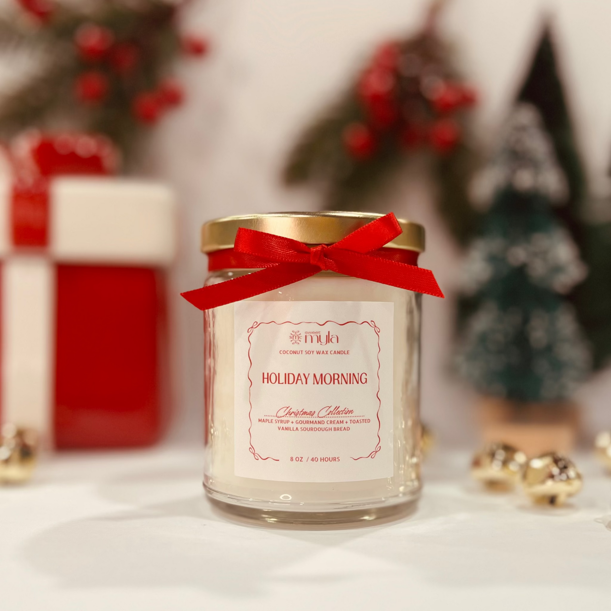 Candle jar with a red bow and 'Holiday Morning' label in a festive setting.