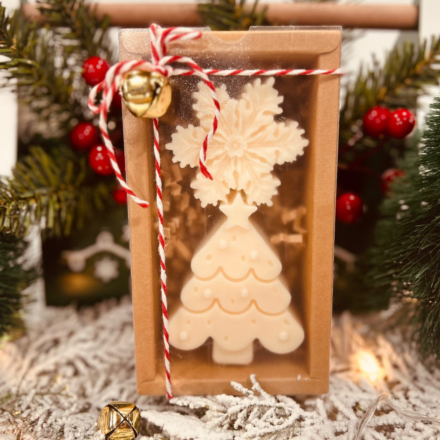 Christmas tree and snowflake Wax melt and candle gift box with decorative string and jingle bells against a festive background.