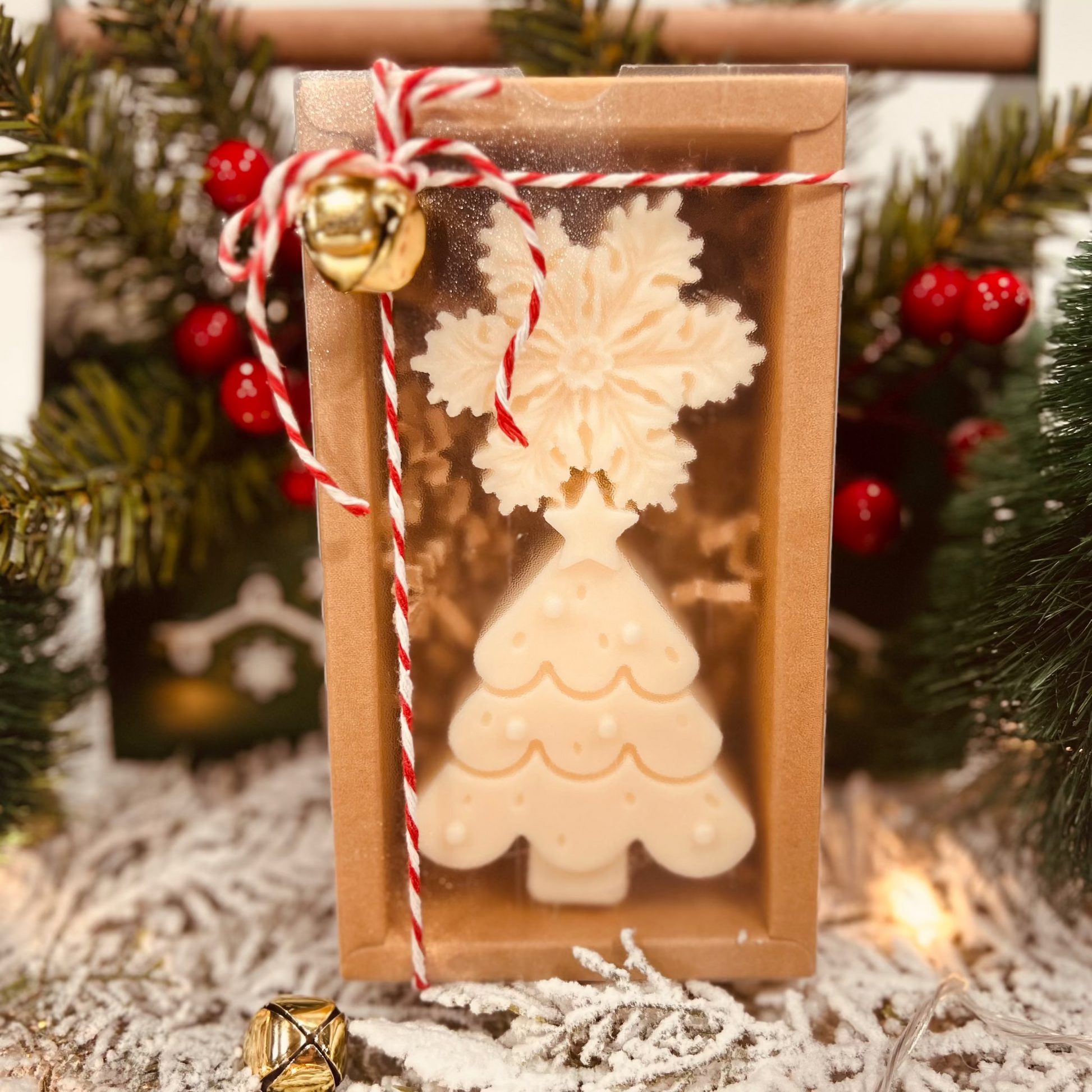 Christmas tree and snowflake Wax melt and candle gift box with decorative string and jingle bells against a festive background.