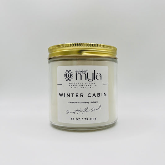 A candle with a label that says Winter Cabin