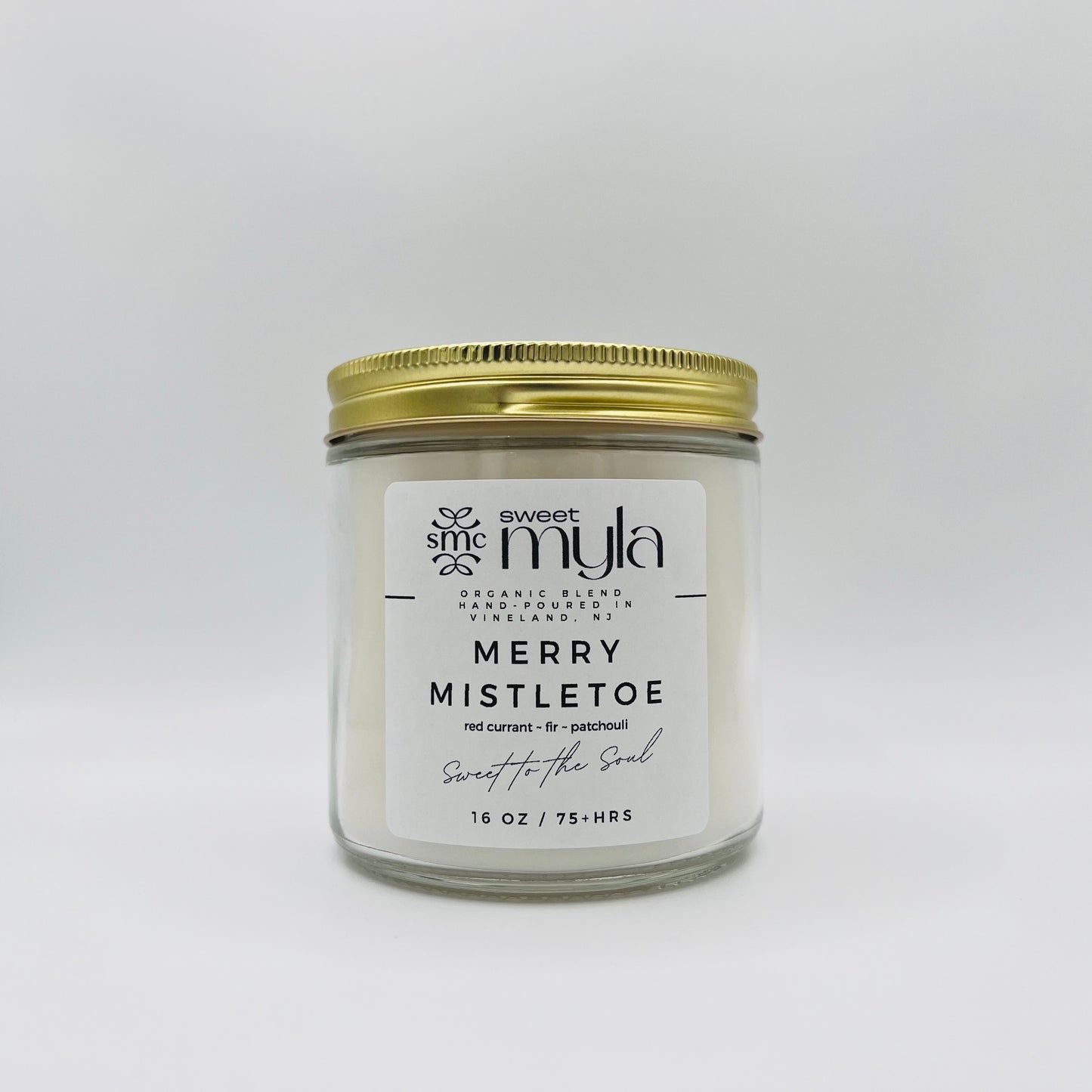 A candle with a label that says Merry Mistletoe