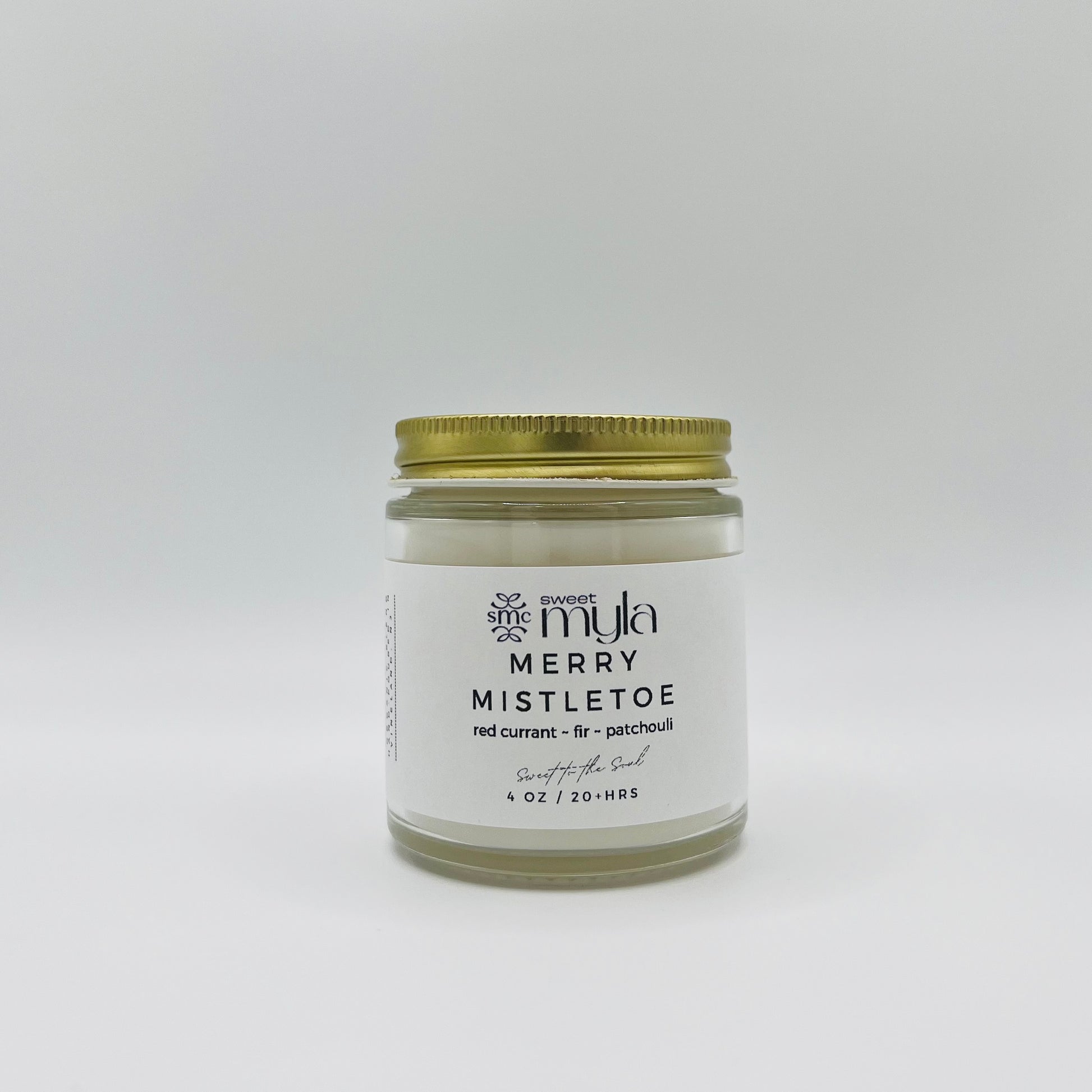 A candle with a label that says Merry Mistletoe