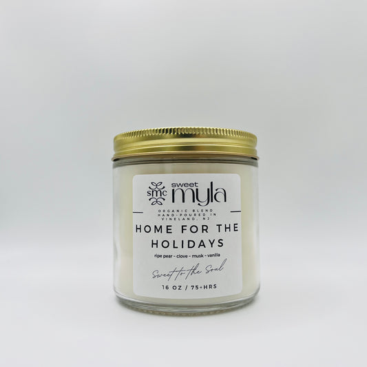 A candle with a label that says Home for the Holidays