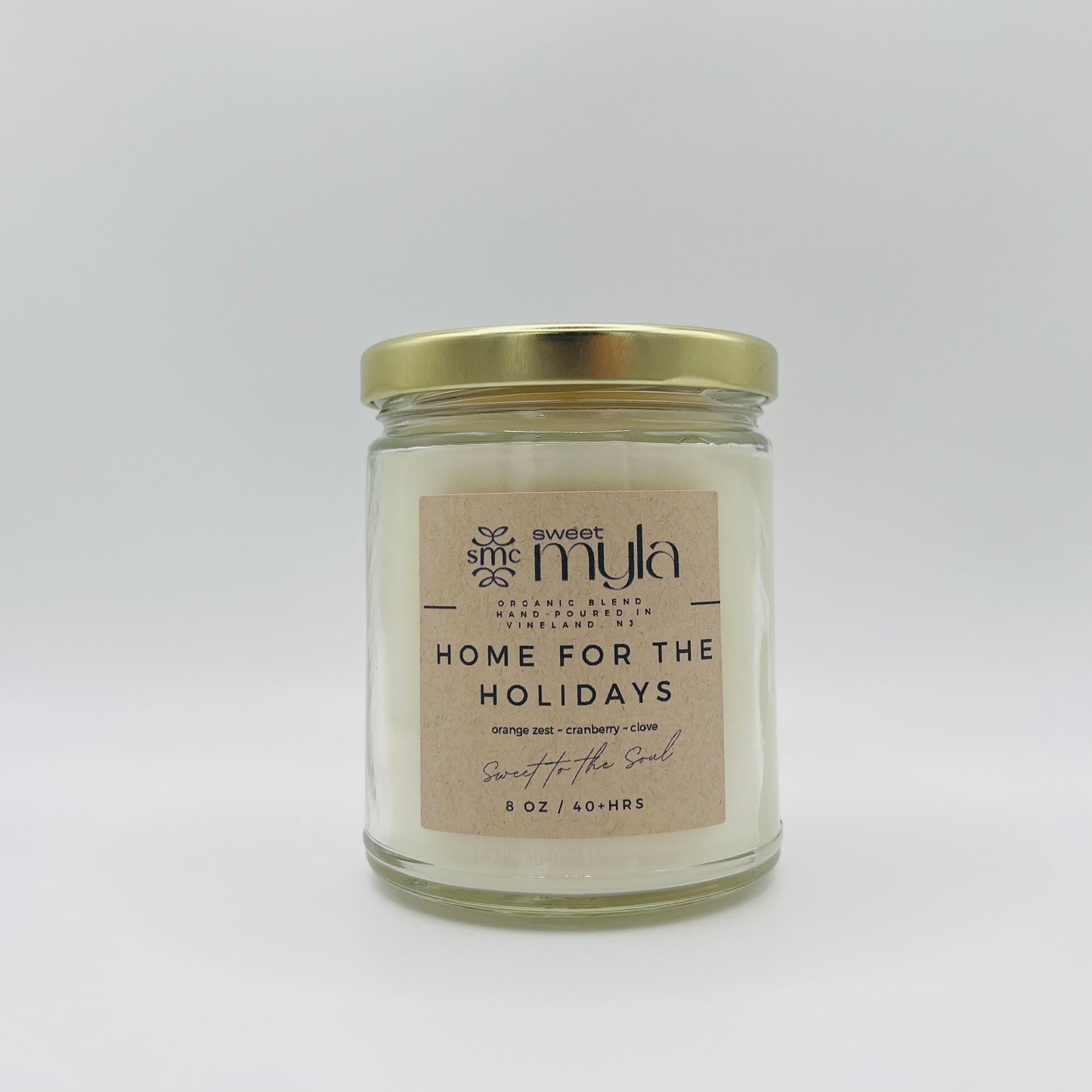 A candle with a label that says Home for the Holidays