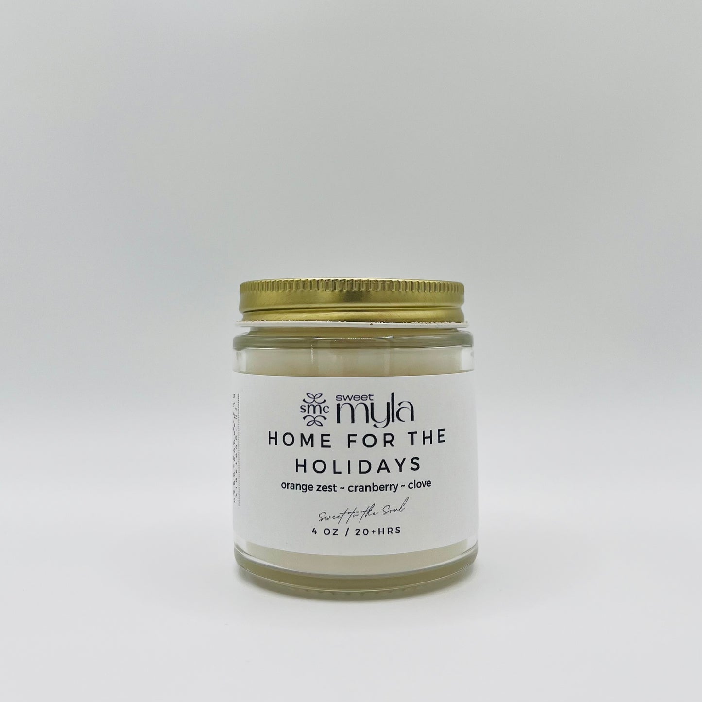 A candle with a label that says Home for the Holidays