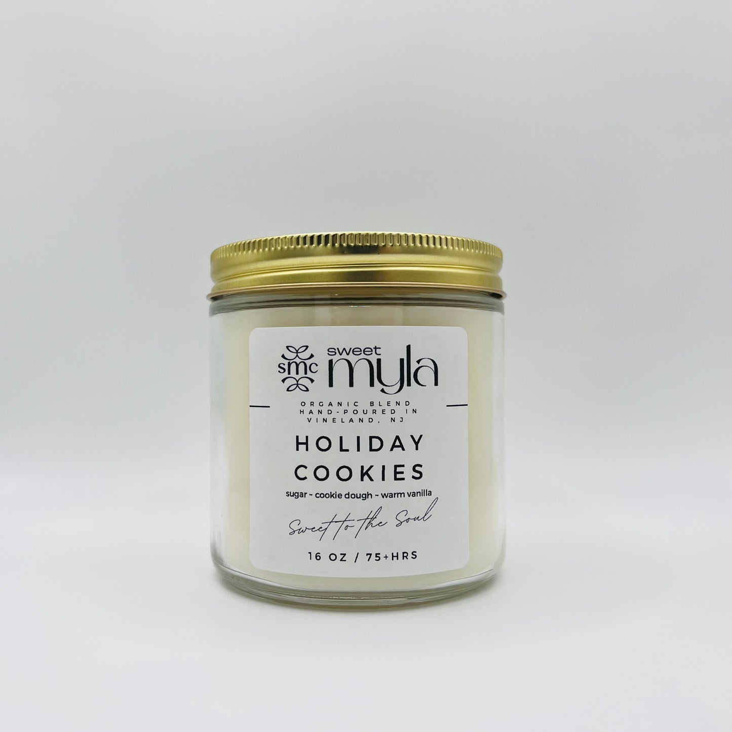 A candle with a label that says Holiday Cookies.