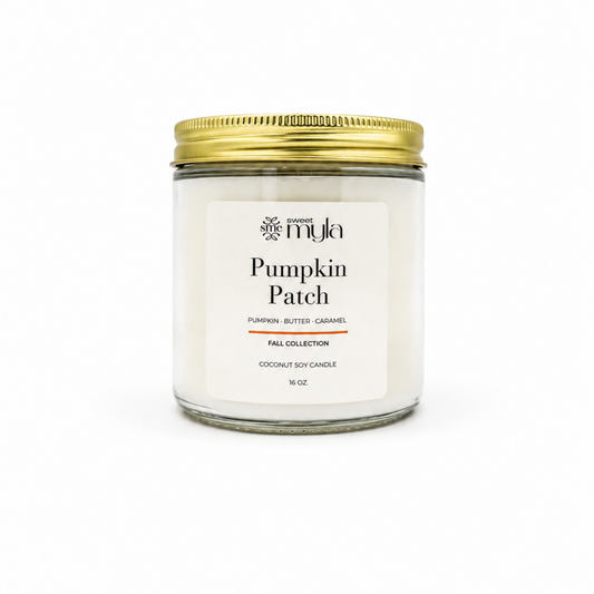 A 16 oz soy candle in a clear glass jar with a white label and a gold metal lid, labeled 'Pumpkin Patch' by the brand Sweet Myla