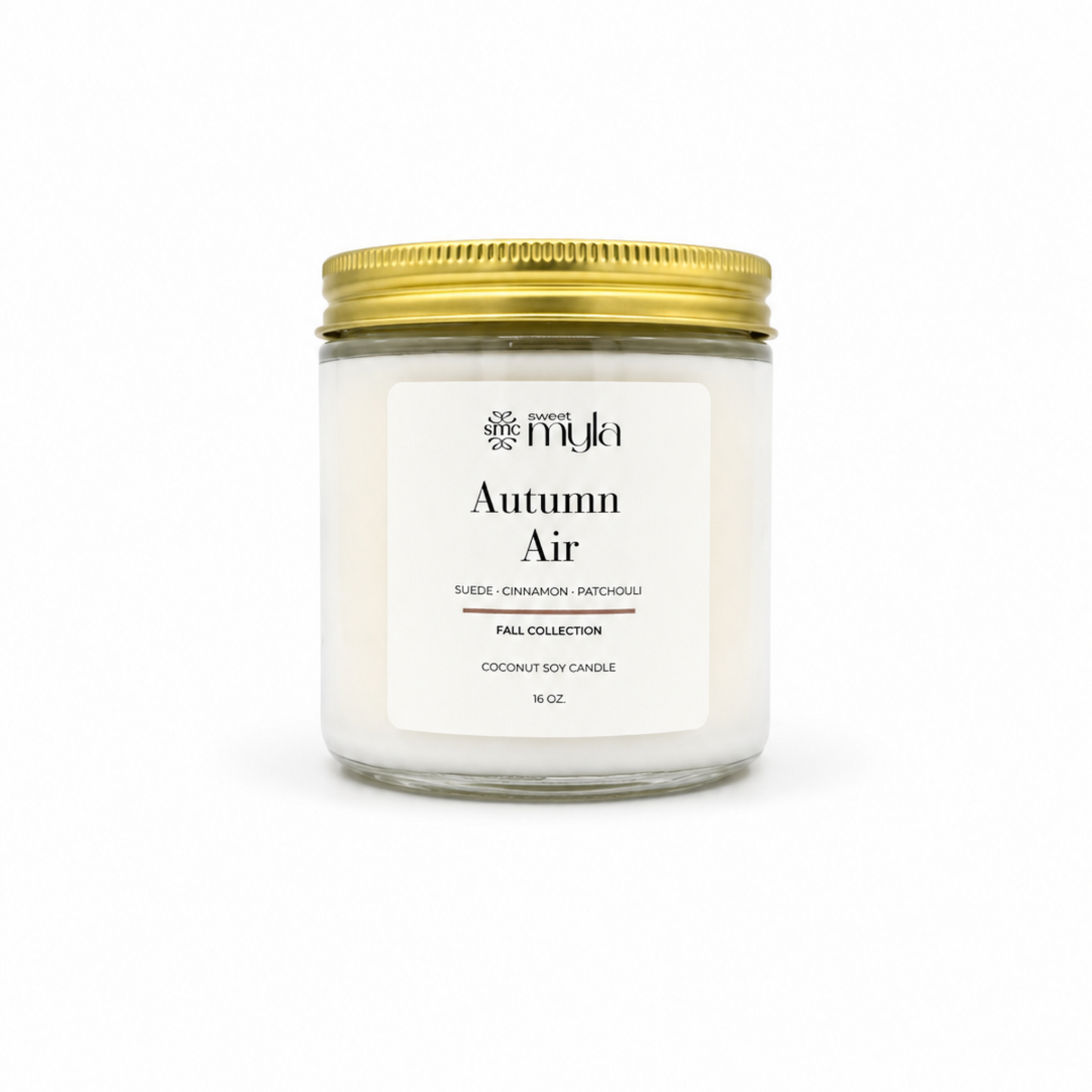A 16 oz coconut soy candle in a clear glass jar with a white label reading 'Autumn Air' by the brand 'Sweet Myla', topped with a metallic gold screw-on lid, set against a plain white background.